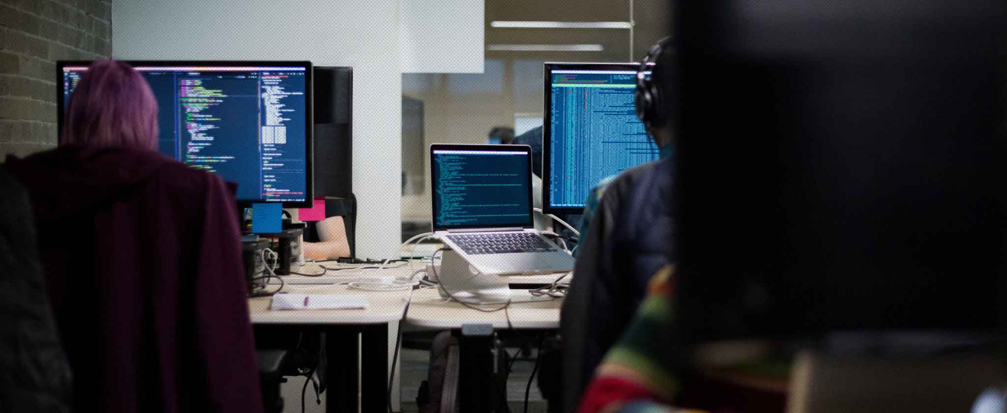 Ufficio di sviluppo con un monitor e un portatile che mostrano codice